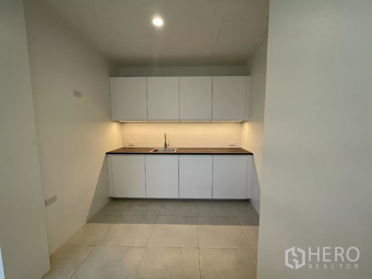 Home Office for rent in Don Mueang, Bangkok - Compact pantry kitchen with white cabinets, sink and under-cabinet lighting.
