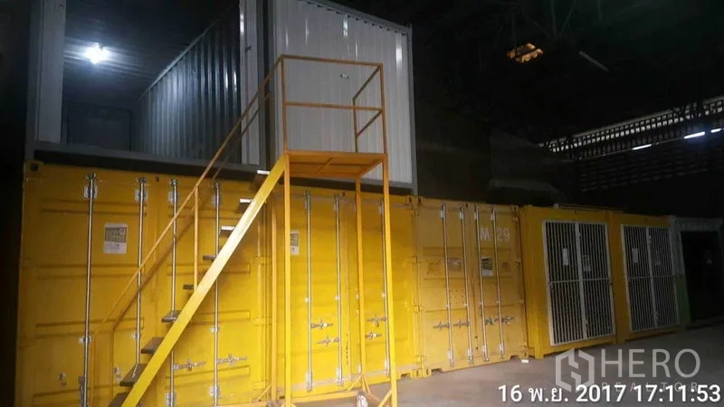 โรงงาน ให้เช่าในBang Phli, Samut Prakan - ภายในโกดัง มีตู้คอนเทนเนอร์ซ้อนกัน บันไดสีเหลือง และโซนเก็บของแบบกรง