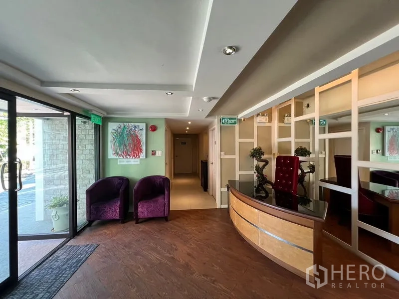 店屋 出租在Suan Luang, Bangkok - 接待大堂，弧形前台、等候区与推拉玻璃门入口。
