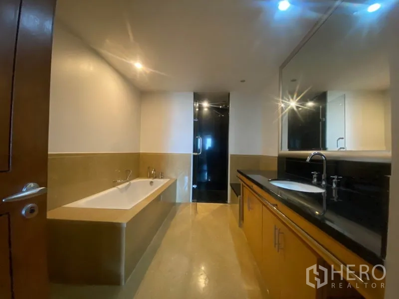 公寓 出租在Sathon, Bangkok - 主浴室设浴缸、长双台面和独立玻璃淋浴间。