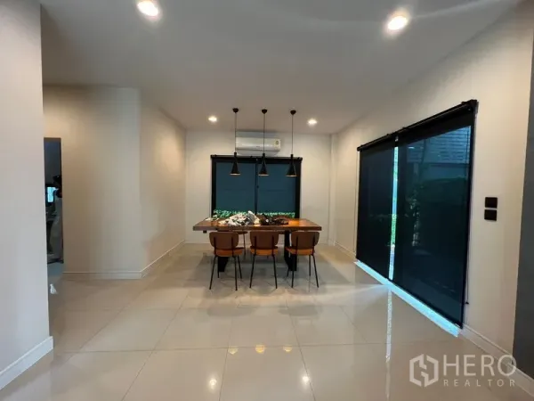 บ้าน ให้เช่าหรือขายในBang Kapi, Bangkok - มุมรับประทานอาหารพร้อมโคมแขวน โต๊ะเก้าอี้ และประตูกระจกพร้อมม่านม้วน