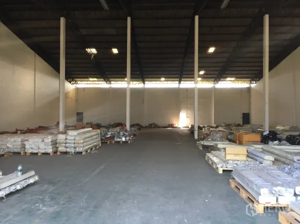 工厂 出租在Pathum Thani - 高挑钢结构屋顶的厂房内部，立柱整齐，地面摆放托盘物料。