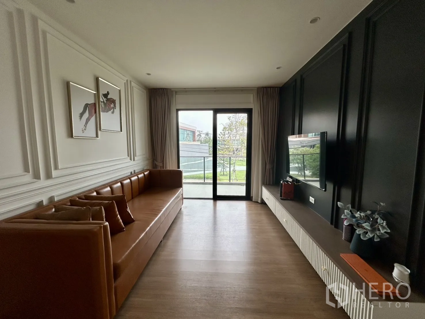 Detached House for rent in Bang Phli, Samut Prakan - Upstairs family lounge with long leather sofa, TV, and balcony doors.