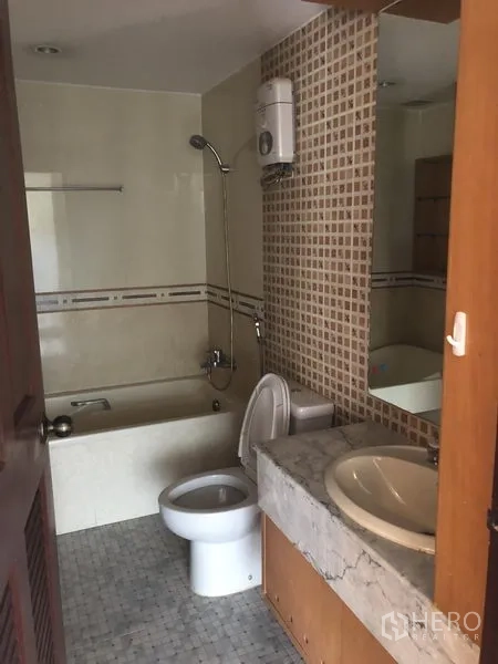 Townhouse for rent or sale in Watthana, Bangkok - Bathroom with bathtub, shower, water heater and a vanity counter.