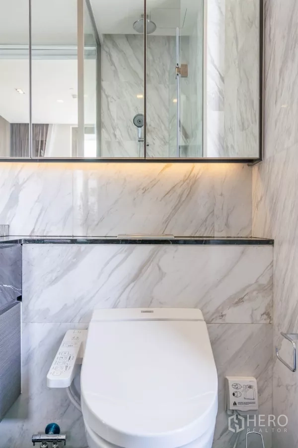 公寓 出租或出售在Bang Rak, Bangkok - 近景展示带控制面板的智能坐便器，墙面大理石装饰。