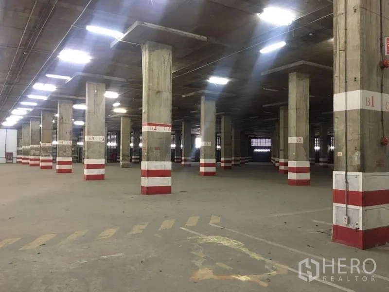 货栈 出租在Phra Pradaeng, Samut Prakan - 仓库通道，红白安全标示立柱与宽阔回转空间。