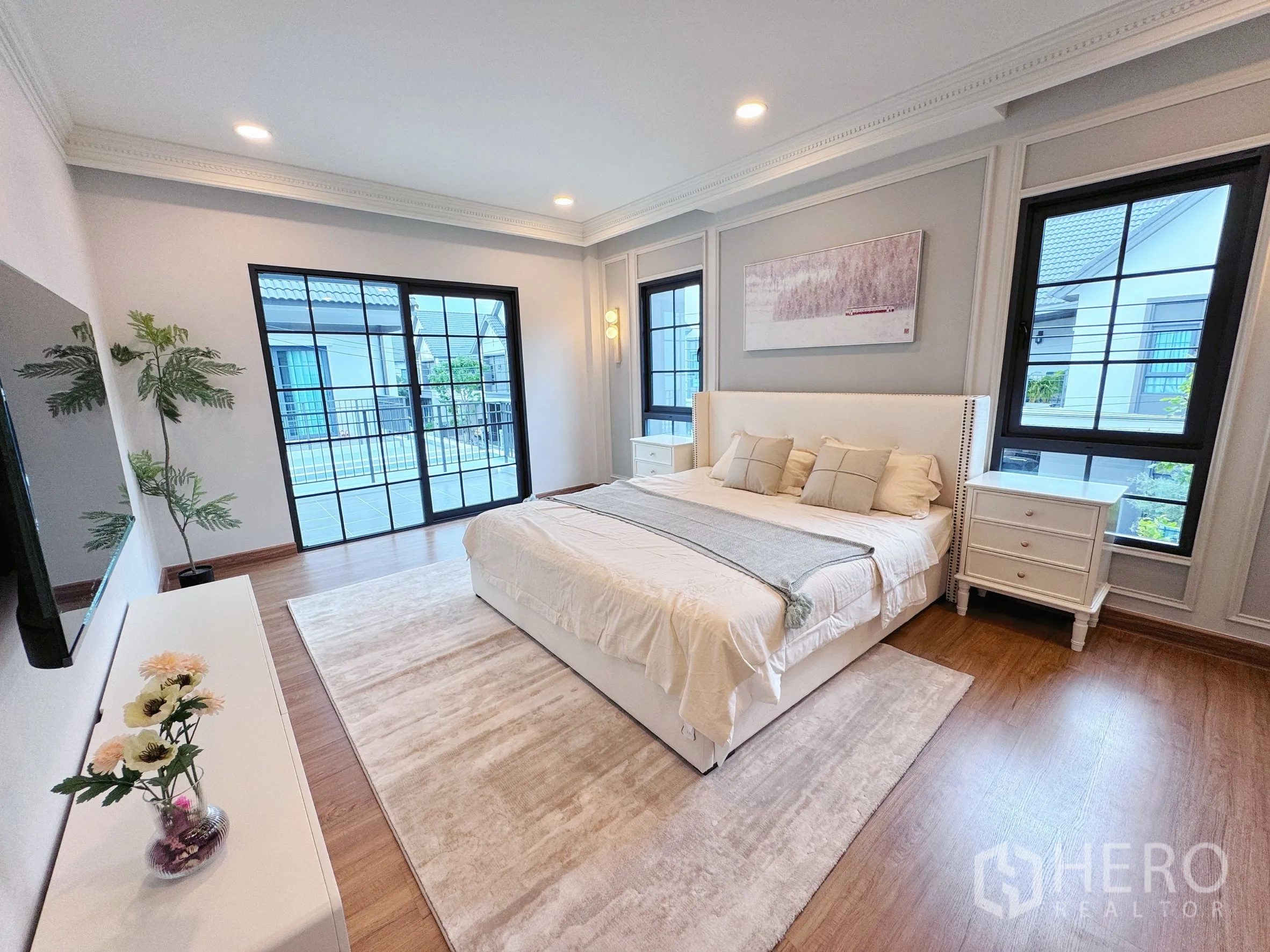 Detached House for rent in Bang Phli, Samut Prakan - Large master bedroom with king bed, balcony doors, windows, and rug.