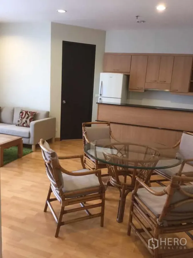 คอนโด ให้เช่าในKhlong Toei, Bangkok - พื้นที่นั่งเล่นและรับประทานอาหารแบบเปิด พร้อมชุดโต๊ะกระจกเก้าอี้หวาย โซฟา และครัวบิวท์อินไม้