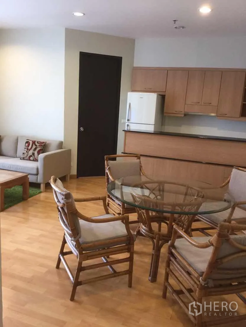 คอนโด ให้เช่าในKhlong Toei, Bangkok - พื้นที่นั่งเล่นและรับประทานอาหารแบบเปิด พร้อมชุดโต๊ะกระจกเก้าอี้หวาย โซฟา และครัวบิวท์อินไม้