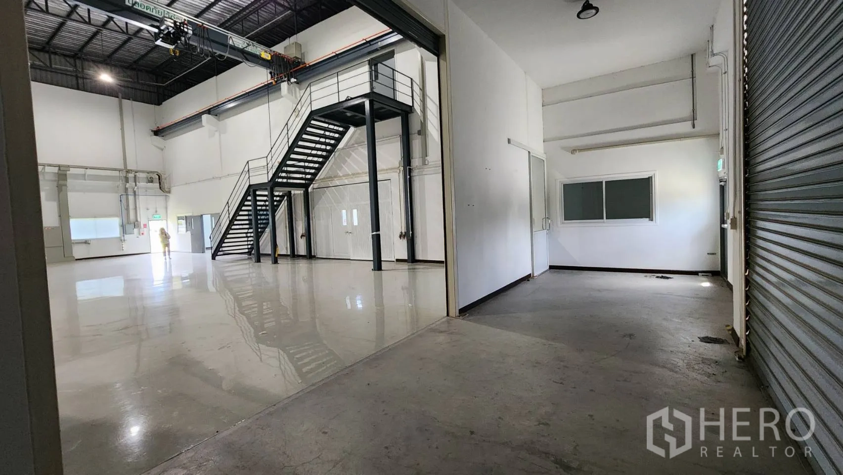 Factory for sale in Bang Bo, Samut Prakan - Polished epoxy production hall with mezzanine stairs and roller shutter.