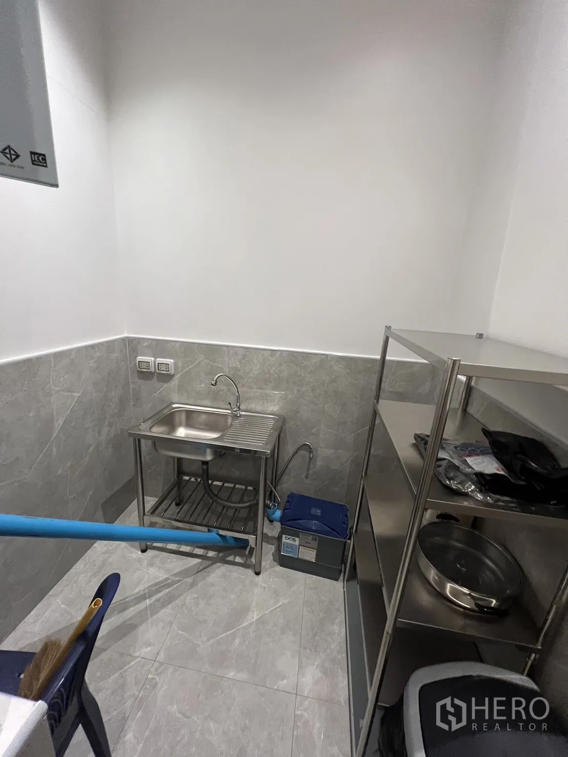 零售空间 出租 - 不锈钢茶水间，带水槽、置物架和外露管线。