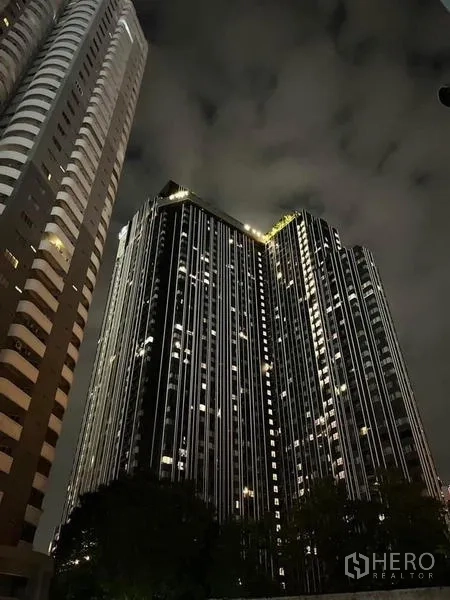 Condominium for rent in Ratchathewi, Bangkok - High-rise condominium tower illuminated against the night sky.