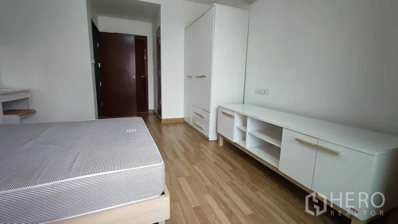 คอนโด ให้เช่าในKhlong Toei, Bangkok - มุมห้องนอนเห็นฐานเตียง ตู้เก็บของเตี้ย และตู้เสื้อผ้าวางลอย พื้นไม้