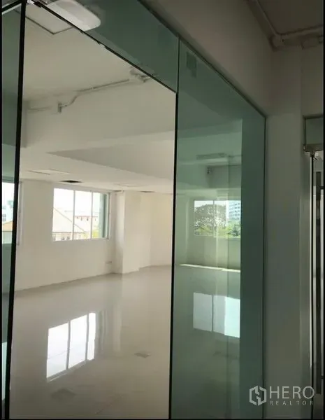 Office Space for rent in Wang Thonglang, Bangkok - Sunlit open‑plan workspace with large windows and glass doors overlooking the neighborhood.
