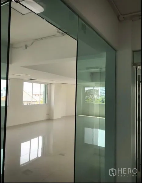 Office Space for rent in Wang Thonglang, Bangkok - Sunlit open‑plan workspace with large windows and glass doors overlooking the neighborhood.