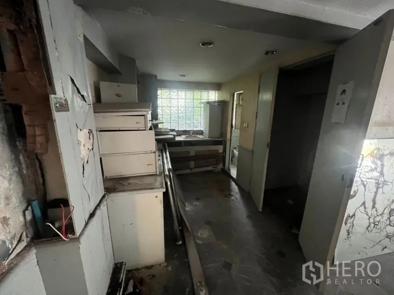 零售空间 出租在Watthana, Bangkok - 后勤区带柜体与玻璃砖采光窗，需翻新。