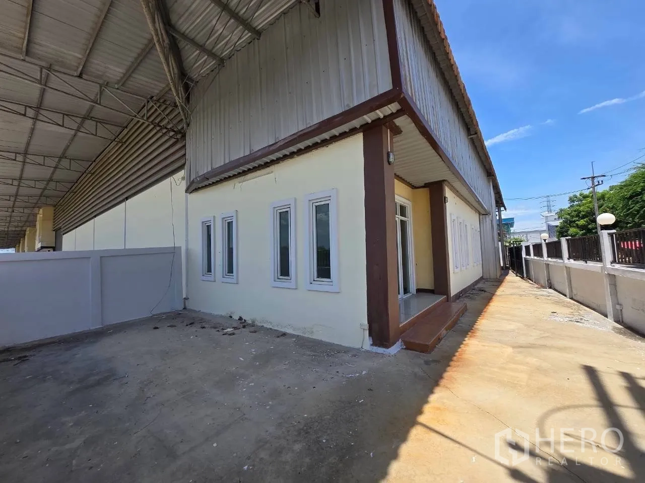 โกดัง for rent or sale in Mueang Samut Sakhon, Samut Sakhon - มุมมองภายนอกโกดังพร้อมบันไดทางเข้า หน้าต่าง และลานคอนกรีตใต้กันสาดขนาดใหญ่