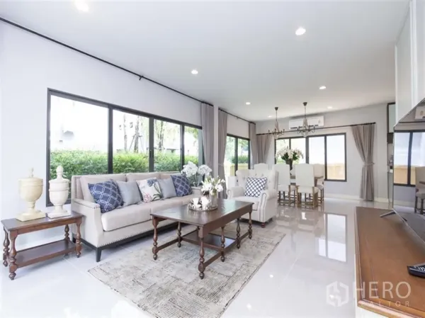 Detached House for rent in Bang Kapi, Bangkok - Bright open-plan living and dining room with large windows, chandeliers, and garden views at Setthasiri Krungthep Kreetha, Bang Kapi.