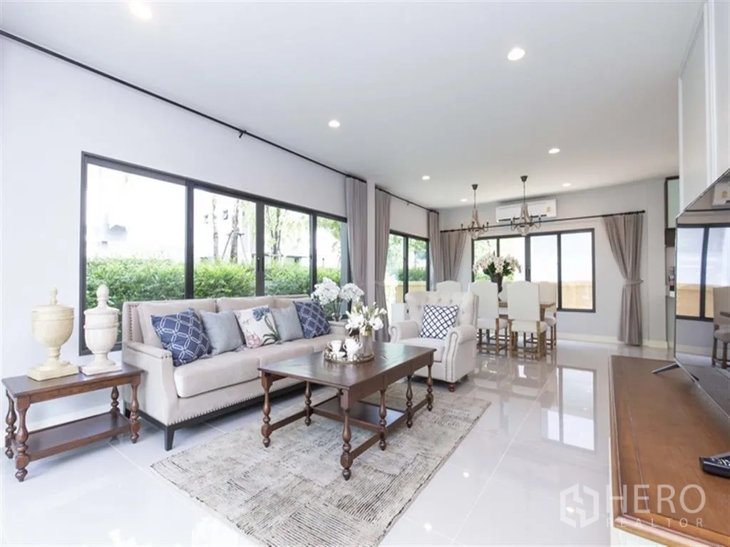 Detached House for rent in Bang Kapi, Bangkok - Bright open-plan living and dining room with large windows, chandeliers, and garden views at Setthasiri Krungthep Kreetha, Bang Kapi.