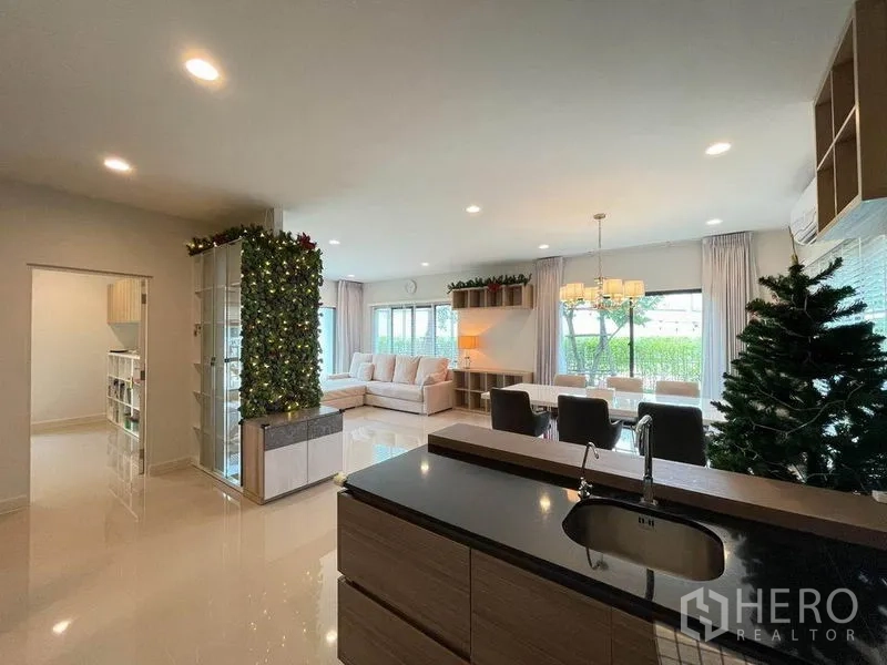 独立式住宅 出售在Pak Kret, Nonthaburi - 开放式中岛厨房，连接采光充足的大客餐厅与落地窗。