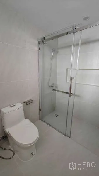 คอนโด ขาย - ห้องน้ำโทนขาว ประตูกระจกบานเลื่อนและโถสุขภัณฑ์