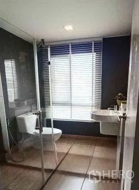Detached House for rent in Don Mueang, Bangkok - Modern bathroom with glass-enclosed shower, vanity and toilet next to a window.