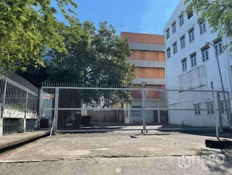 โรงงาน ให้เช่าในPhra Samut Chedi, Samut Prakan - ทางวิ่งกว้างและประตูรั้วเลื่อนโลหะคั่นระหว่างอาคารโรงงานสีขาวและสีส้ม