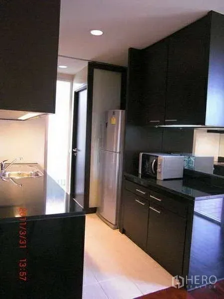 บ้าน ให้เช่าในWang Thonglang, Bangkok - ครัวรูปแบบแกลเลอรี ตู้สีเข้ม ท็อปหิน ซิงก์ และตู้เย็นสเตนเลส