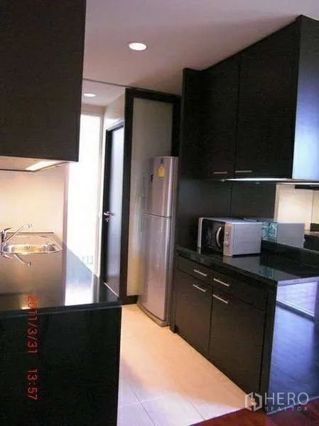บ้าน ให้เช่าในWang Thonglang, Bangkok - ครัวรูปแบบแกลเลอรี ตู้สีเข้ม ท็อปหิน ซิงก์ และตู้เย็นสเตนเลส