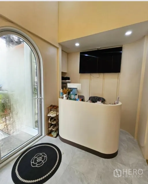 พื้นที่ขายปลีก ให้เช่าในWatthana, Bangkok - เคาน์เตอร์ต้อนรับทรงโค้ง ใกล้ประตูกระจกโค้ง และทีวี