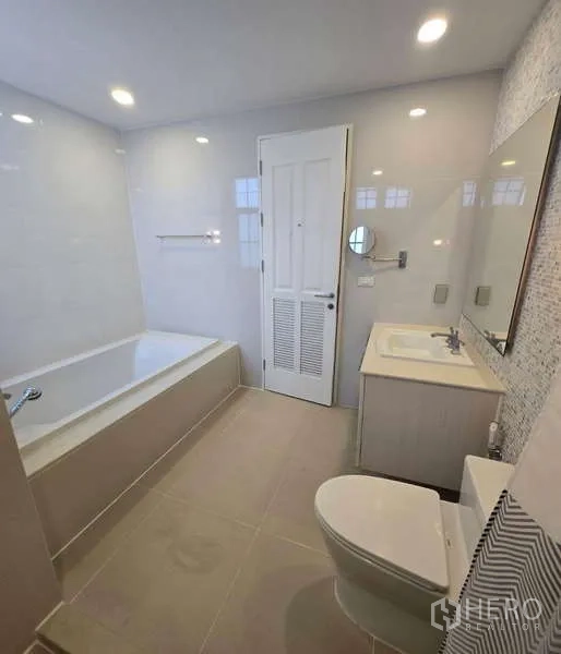 Townhouse for sale in Watthana, Bangkok - Bathroom with bathtub, vanity and soft lighting.