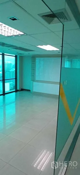 Office Space for rent in Huai Khwang, Bangkok - Open-plan office area with built-in shelving and large windows for natural light.