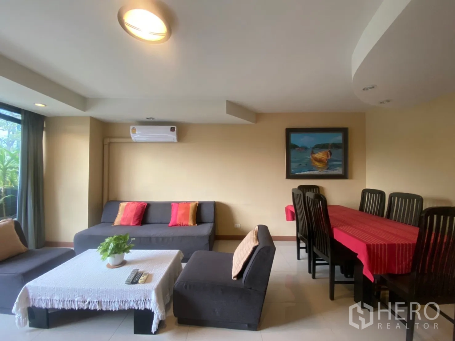 คอนโด ให้เช่าในPhaya Thai, Bangkok - ห้องนั่งเล่นสว่างพร้อมโซฟาสีเทา หมอนสีสัน และโต๊ะทานอาหารในคอนโด