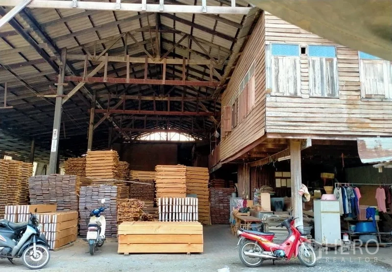 Warehouse for sale in Mueang Nonthaburi, Nonthaburi - Main warehouse bay with extensive timber stacks and a raised wooden office.