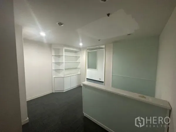 办公空间 出租在Khlong Toei, Bangkok - 前台接待区，接待台、内置展示柜、筒灯与磨砂玻璃隔断。