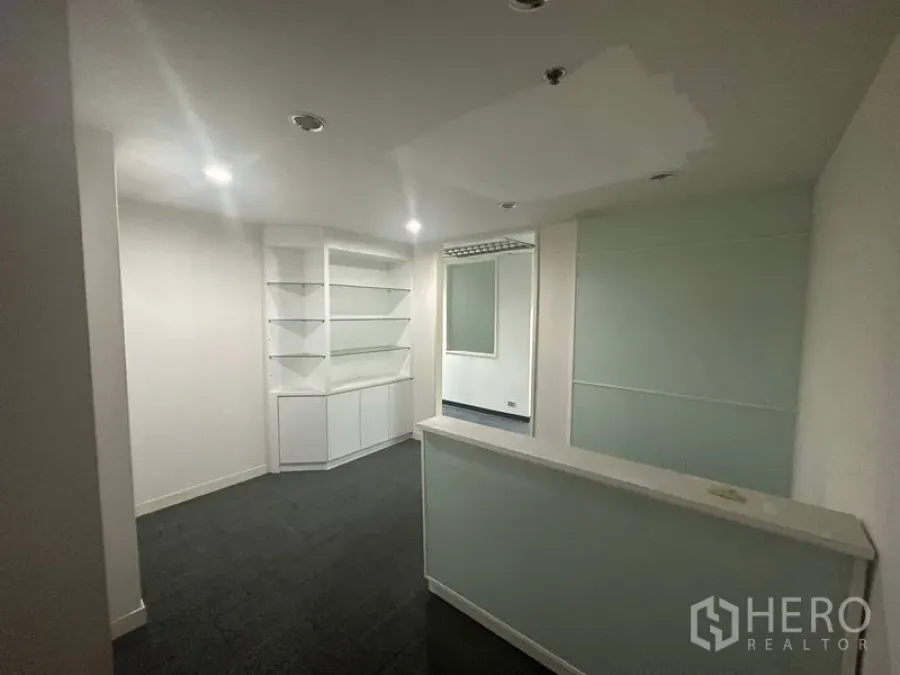 办公空间 出租在Khlong Toei, Bangkok - 前台接待区，接待台、内置展示柜、筒灯与磨砂玻璃隔断。