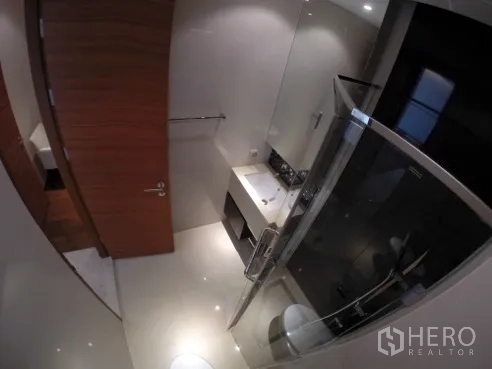 公寓 出租在Khlong Toei, Bangkok - 现代卫浴，玻璃淋浴间、台盆与壁挂式马桶。