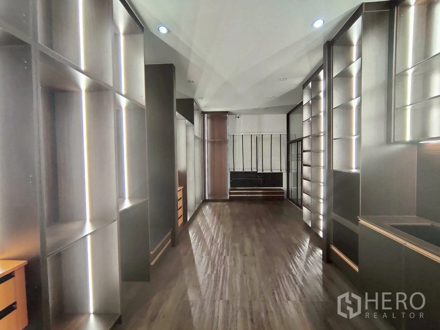 Warehouse for rent in Lam Luk Ka, Pathum Thani - Fitted office or showroom with built-in shelving, lighting and wood flooring.