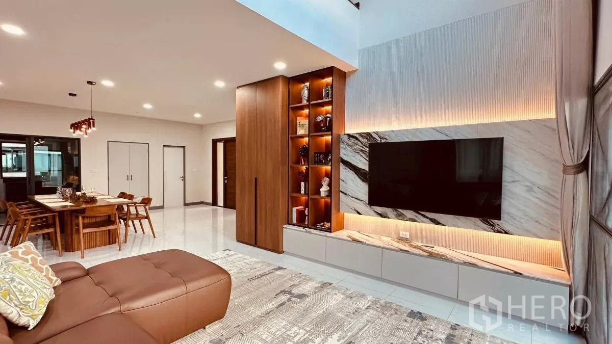 Detached House for rent in Bang Phli, Samut Prakan - View from the leather sofa toward the feature TV wall and dining zone in a modern open space.