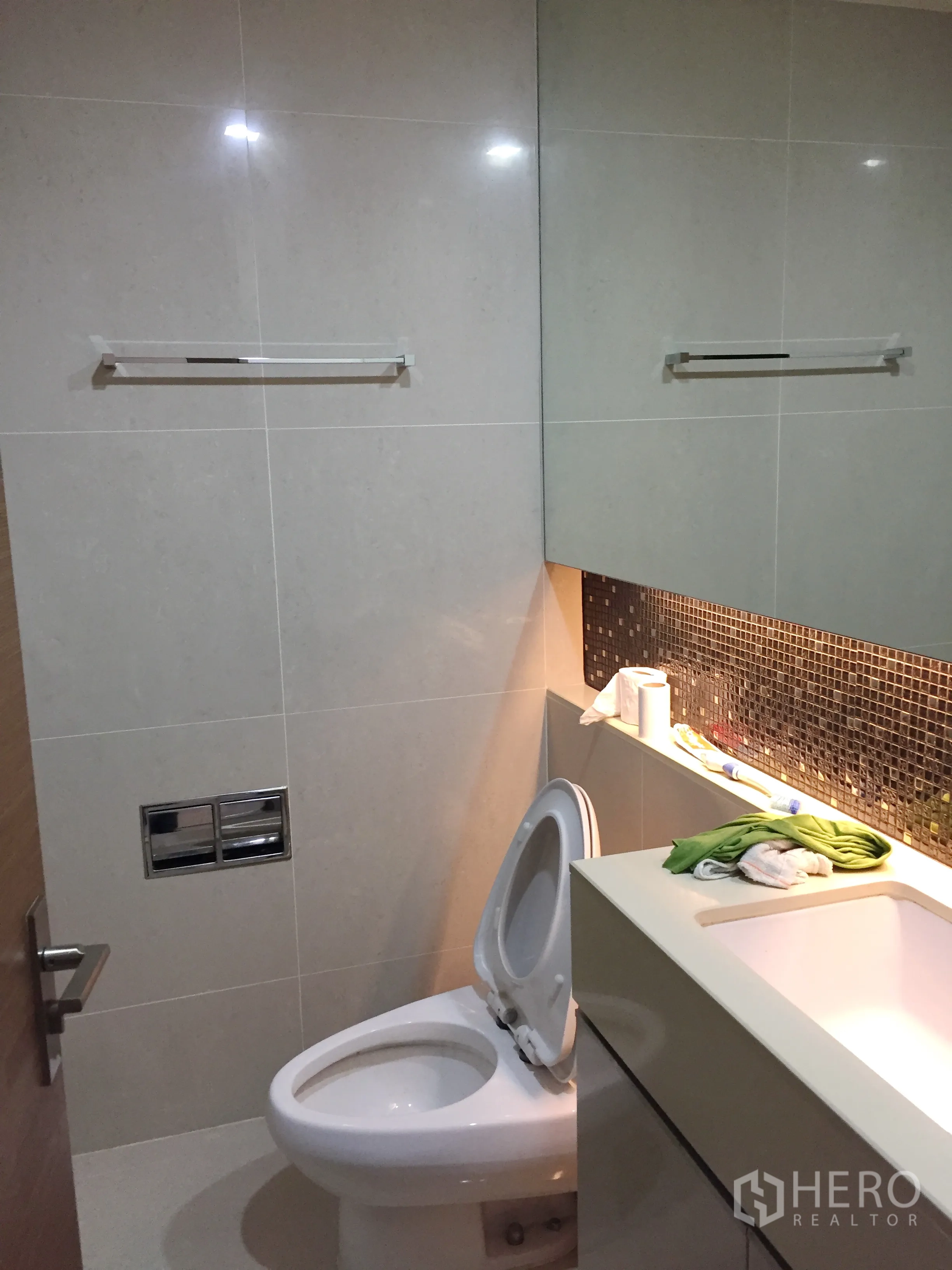 公寓 出租在Bang Rak, Bangkok - 现代化浴室，带洗手台、马赛克背墙与坐便器，干净整洁。