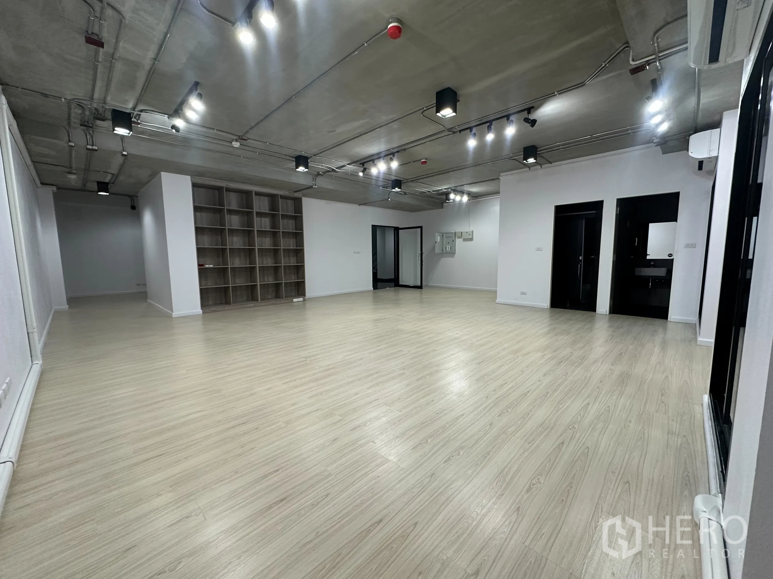 Office Space for rent in Watthana, Bangkok - Spacious workspace featuring built-in shelving, private restroom doors and split-type air conditioning.