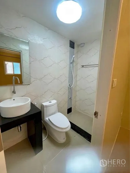 Townhouse for rent - Modern bathroom featuring a walk-in shower, mirror and countertop basin.