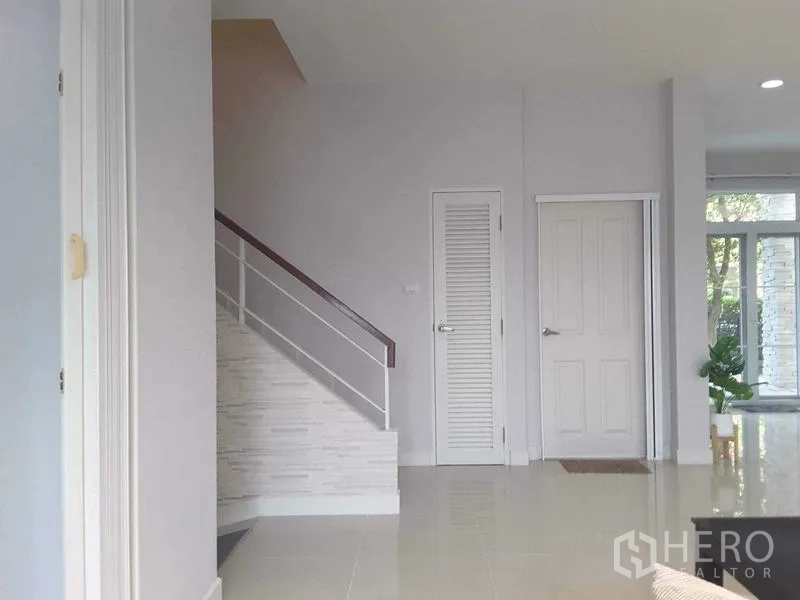 บ้าน ให้เช่าในLam Luk Ka, Pathum Thani - โถงทางเดินพร้อมบันไดราวสีขาว และประตูเก็บของสไตล์มินิมอล