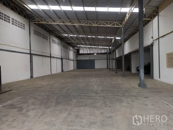 Warehouse for rent in Suan Luang, Bangkok - Spacious clear-span warehouse hall with support columns and wide concrete loading space.