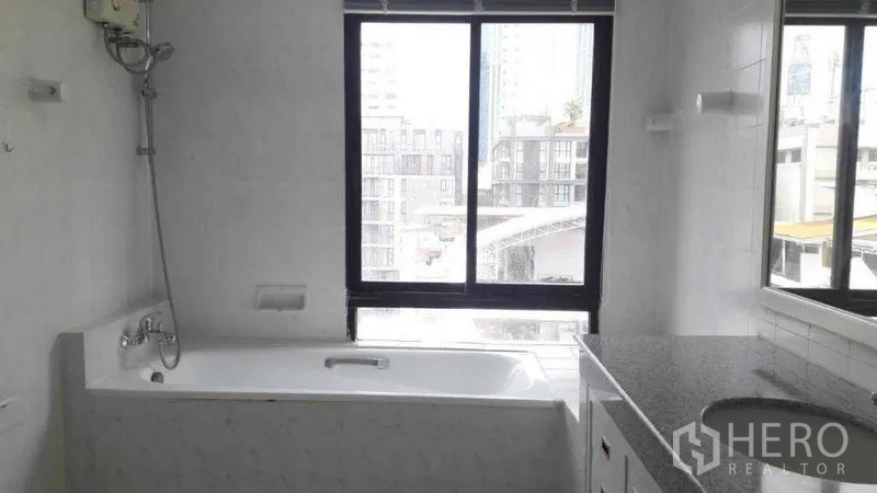 อพาร์ทเมนท์ ให้เช่าในPathum Wan, Bangkok - ห้องน้ำพร้อมอ่างอาบน้ำ หน้าต่างมองวิวเมือง และเคาน์เตอร์หินแกรนิตยาว