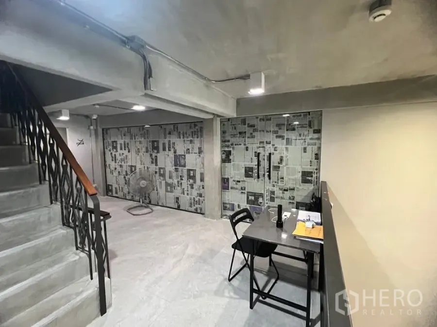 พื้นที่ขายปลีก ให้เช่าในWatthana, Bangkok - ภายในพื้นที่ค้าปลีกสไตล์ลอฟต์ คอนกรีตเปลือย ผนังกระจก บันไดเหล็ก และมุมโต๊ะทำงาน ใกล้บีทีเอสพร้อมพงษ์