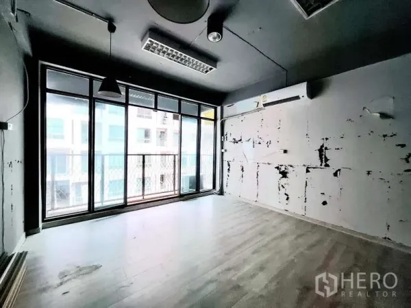 店屋 出租在Bang Rak, Bangkok - 空房间，落地窗与小阳台，灰色天花与木纹地板。