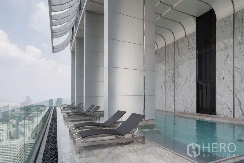 公寓 出租在Watthana, Bangkok - 空中泳池平台，躺椅与玻璃栏杆俯瞰城市