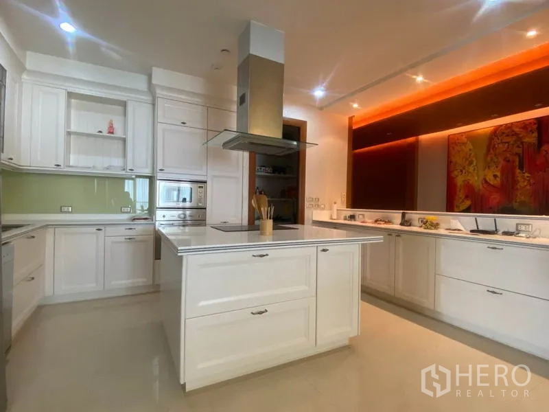 公寓 出租在Sathon, Bangkok - 明亮白色厨房，中岛台、嵌入式烤箱与岛式油烟机。