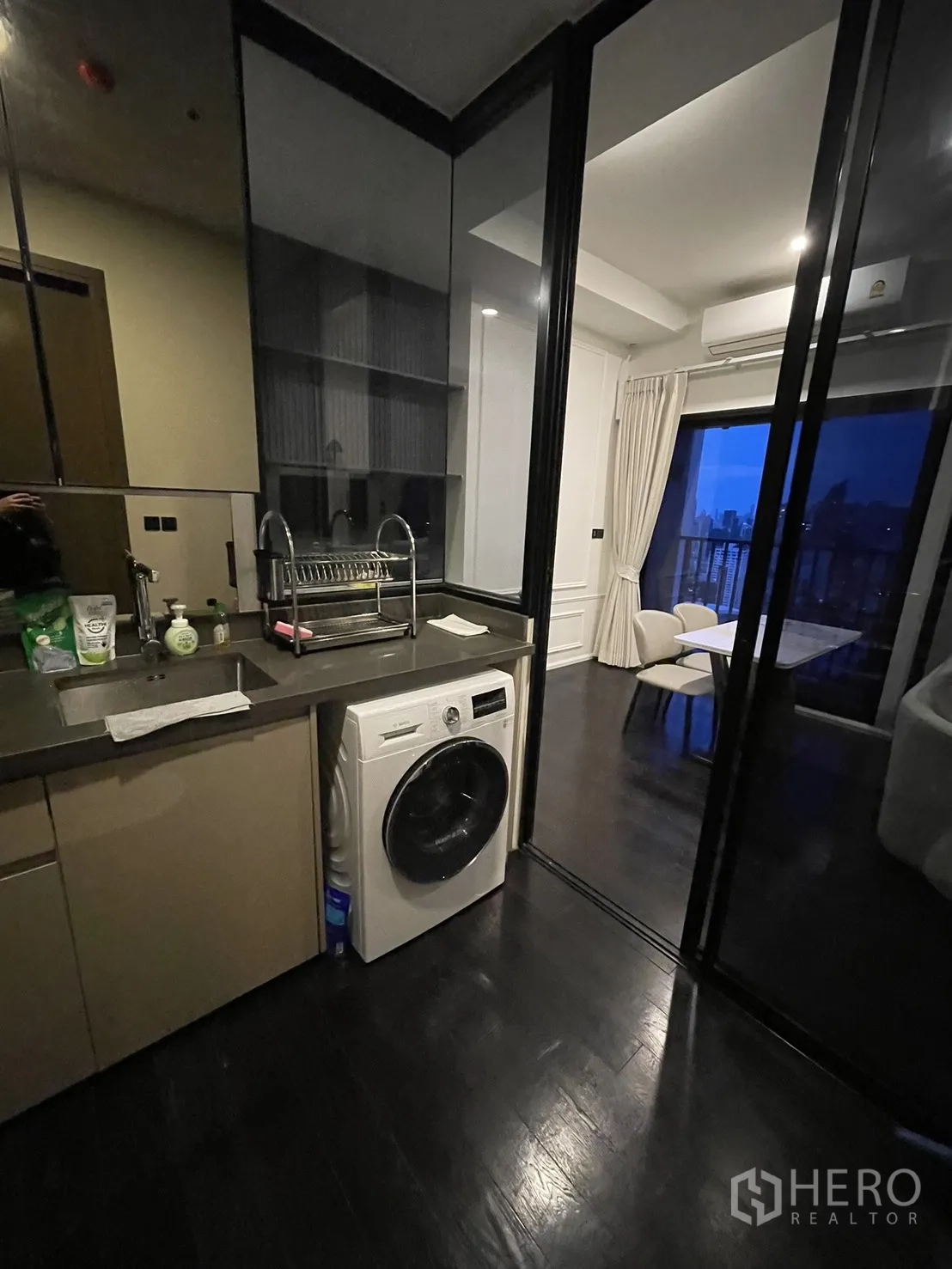 Condominium for rent in Watthana, Bangkok - Enclosed kitchen with sink, countertop, shelving, and front-load washer.